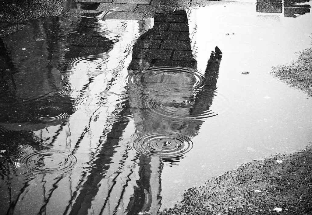 Reflejo de una persona en el agua del suelo